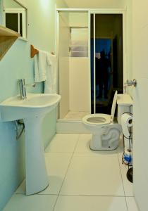 La salle de bains blanche est pourvue de toilettes et d'un lavabo. dans l'établissement Sands Great Bay, à Treasure Beach