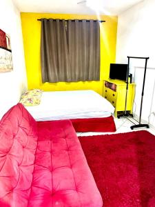 Schlafzimmer mit einem Bett und einem roten Teppich in der Unterkunft Kitinete confortável frente ao mar in Santos