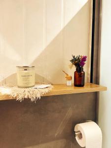 a bathroom shelf with a candle and flowers on it at Cozy Tiny Home with Outdoor Hot Tub in City Center in Davao City