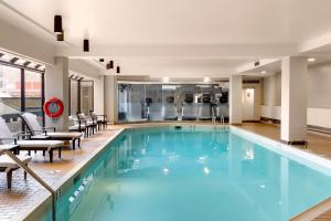 una piscina en un hotel con sillas y mesas en The Westin Edmonton en Edmonton