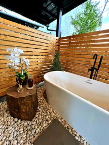 a bath tub in a bathroom with a tree stump next to it at Cozy Tiny Home with Outdoor Hot Tub in City Center in Davao City