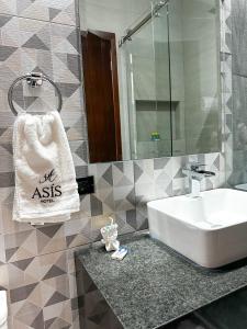 a bathroom with a sink and a towel on a counter at Hotel Asís in San Juan de los Lagos