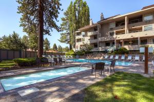 une piscine avec des chaises et un bâtiment dans l'établissement Lakeland Village 496 - 4 Seasons Family Fun, à South Lake Tahoe