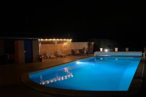 una gran piscina por la noche con iluminación azul en The Bamboos - private heated swimming pool, en Lagnes