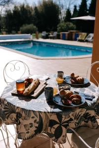una mesa con platos de comida junto a una piscina en The Bamboos - private heated swimming pool, en Lagnes