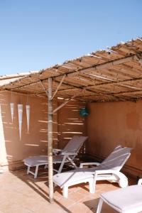 un patio con 2 sillas y una sombrilla en The Bamboos - private heated swimming pool, en Lagnes