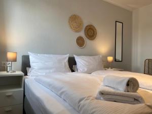 a bedroom with a large white bed with towels on it at STRANDNEST NORDDEICH in Norddeich