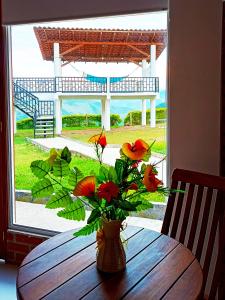 un vase avec des fleurs assis sur une table en bois dans l'établissement Hotel Kasama, à San Agustín
