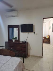a bedroom with a flat screen tv on a wall at to little away from El conde ,museums, parks in the colonia zone in Santo Domingo
