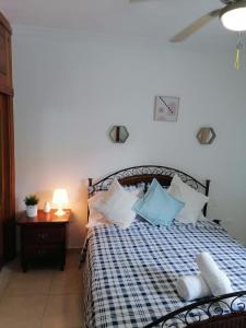 a bedroom with a bed with blue and white pillows at to little away from El conde ,museums, parks in the colonia zone in Santo Domingo