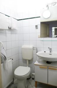 biała łazienka z toaletą i umywalką w obiekcie Apartment Trappelgasse w Wiedniu