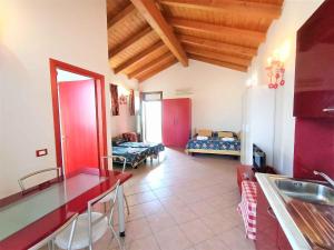 cocina con armarios rojos y sala de estar. en Studio in Isola di Albarella 49973, en Caleri