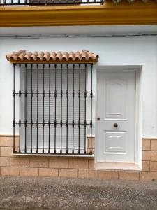 een witte deur en een poort op een gebouw bij Apartamento avenida de la musica in Conil de la Frontera