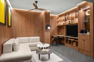 a living room with a couch and a tv at Cardo Roma, Autograph Collection in Rome