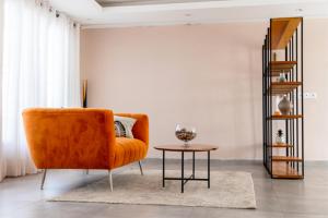 pomarańczowa kanapa w salonie ze stołem w obiekcie Comfy 3 Bedroom Apartment in Ngor Almadies, Dakar w mieście Dakar