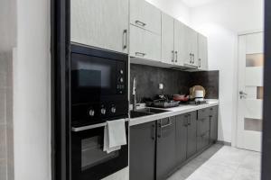 uma cozinha com um micro-ondas e um forno preto em Comfy 3 Bedroom Apartment in Ngor Almadies, Dakar em Dakar