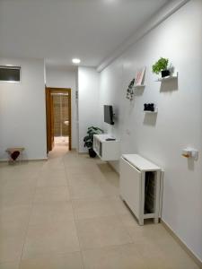 een hal met witte muren en een tegelvloer bij Apartamento avenida de la musica in Conil de la Frontera