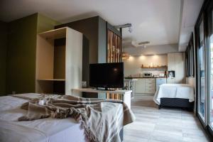 um quarto com uma cama, uma televisão e uma cozinha em Departamento del río Paraná de las Palmas em Campana