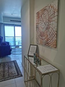 een woonkamer met een tafel en een schilderij aan de muur bij Luxury stay in Marina in Dubai
