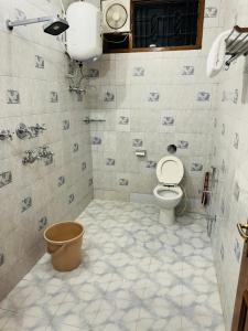 uma casa de banho em azulejo com um WC e um lavatório. em Riya Villa - Entire Villa (Kaashi Flora) em Varanasi