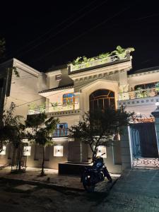 a motorcycle parked in front of a building at night at Riya Villa - Entire Villa (Kaashi Flora) in Varanasi