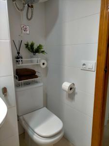 een witte badkamer met een toilet en een wastafel bij Apartamento avenida de la musica in Conil de la Frontera