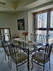 een eetkamer met een glazen tafel en stoelen bij Luxury stay in Marina in Dubai