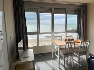 a dining room with a table and chairs and the ocean at Torrenostra Sea Dream in Torreblanca