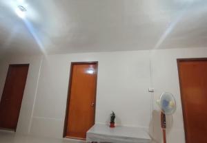 a white room with a fan and a door at Villa Travellers House in Moalboal