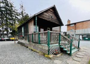 a small house with a green front porch on a street at Bridge Tender Shack with hot tub on deck in La Conner