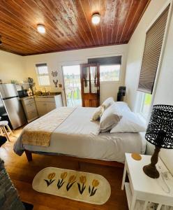 1 dormitorio con 1 cama grande y techo de madera en Bridge Tender Shack with hot tub on deck, en La Conner