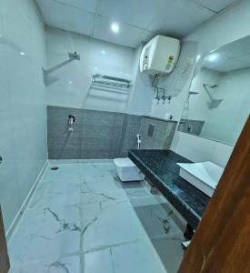 Hotel Gross International near delhi airport في نيودلهي: حمام أبيض مع حوض ومرحاض