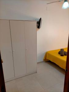 een slaapkamer met een witte kast naast een bed bij Apartamento avenida de la musica in Conil de la Frontera