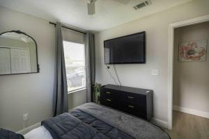 1 dormitorio con 1 cama y TV de pantalla plana en Entire 2 Bd Home w/ Murals + Parking by Downtown, en Orlando