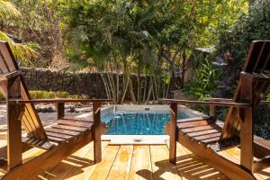 un patio con 2 sillas y una piscina en Casa Mono del Río en Matapalo
