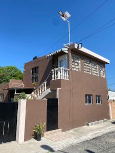 ein braunes Gebäude mit einer Flagge darüber in der Unterkunft Bleesed House in Monte Adentro
