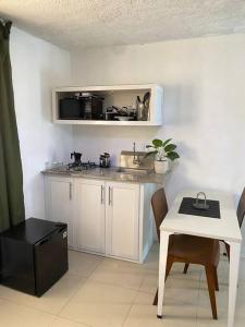 a small kitchen with a sink and a table with a table at Bleesed house tu lugar in Monte Adentro
