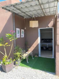 a patio with a table and a bench and plants at Bleesed House in Monte Adentro