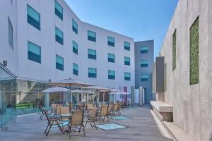 a patio with chairs and umbrellas in front of a building at City Express by Marriott Ciudad de Mexico Aeropuerto in Mexico City