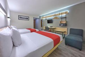 um quarto de hotel com duas camas e uma secretária em City Express by Marriott Ciudad de Mexico Aeropuerto em Cidade do México