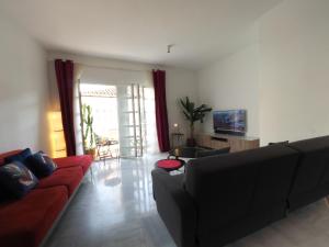 a living room with a couch and a tv at Ollerías 35 by Nagoa Homes in Málaga