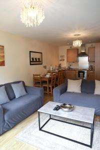 Luxury Apartment New Street Birmingham Feel At Home في برمنغهام: غرفة معيشة مع كنبتين زرقاوين وطاولة