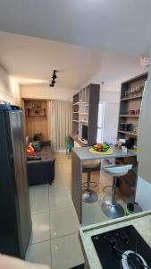 a kitchen and living room with a couch and a table at Confortável Studio no Park Sul próximo ao aeroporto in Brasília