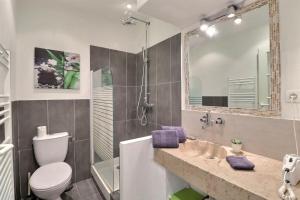 een badkamer met een toilet, een wastafel en een spiegel bij Studio Hyper centre de Cassis in Cassis