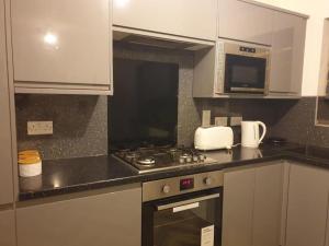 una cucina con piano cottura e forno a microonde di Oasis Abode @ Ashover Newcastle a Kenton