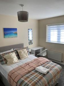 Oasis Abode @ Ashover Newcastle في Kenton: غرفة نوم بسرير ومكتب ونافذة