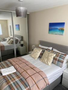 Oasis Abode @ Ashover Newcastle في Kenton: غرفة نوم بسريرين ومرآة