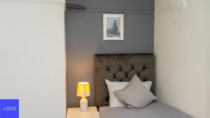 a bedroom with a bed with a headboard and a lamp at 2ndHomeStays-Dudley-Sleeps 12 in Dudley