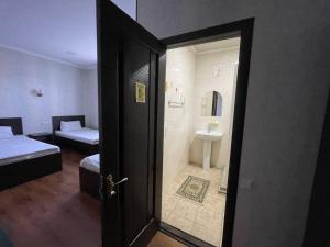 a room with a bathroom with a shower and a bed at Гостевой дом Вояж in Karakol