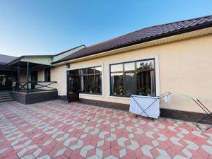 a house with a red tile floor and a building at Гостевой дом Вояж in Karakol